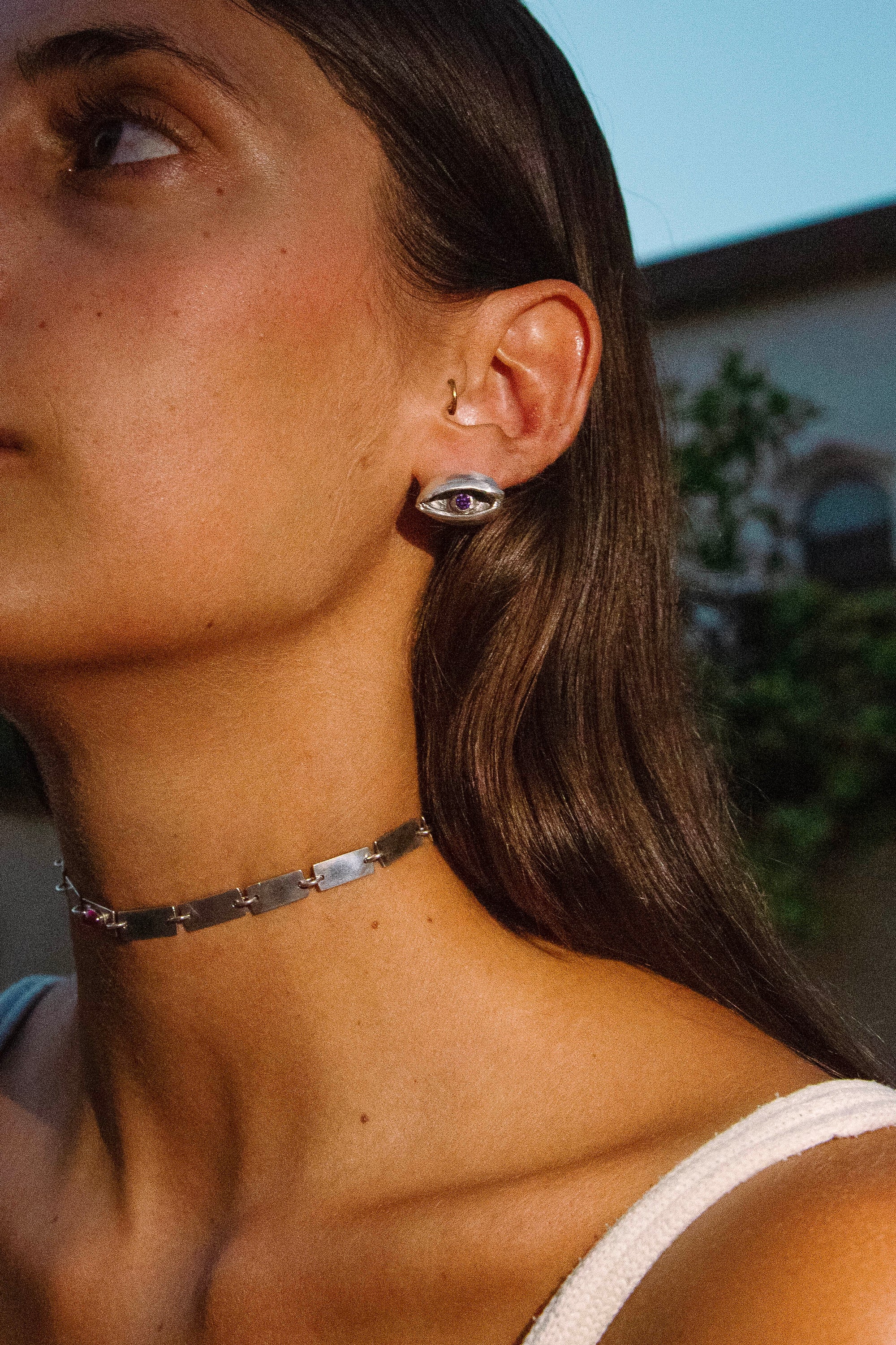 EYES WIDE SHUT earrings worn, displaying allure and enigmatic styling