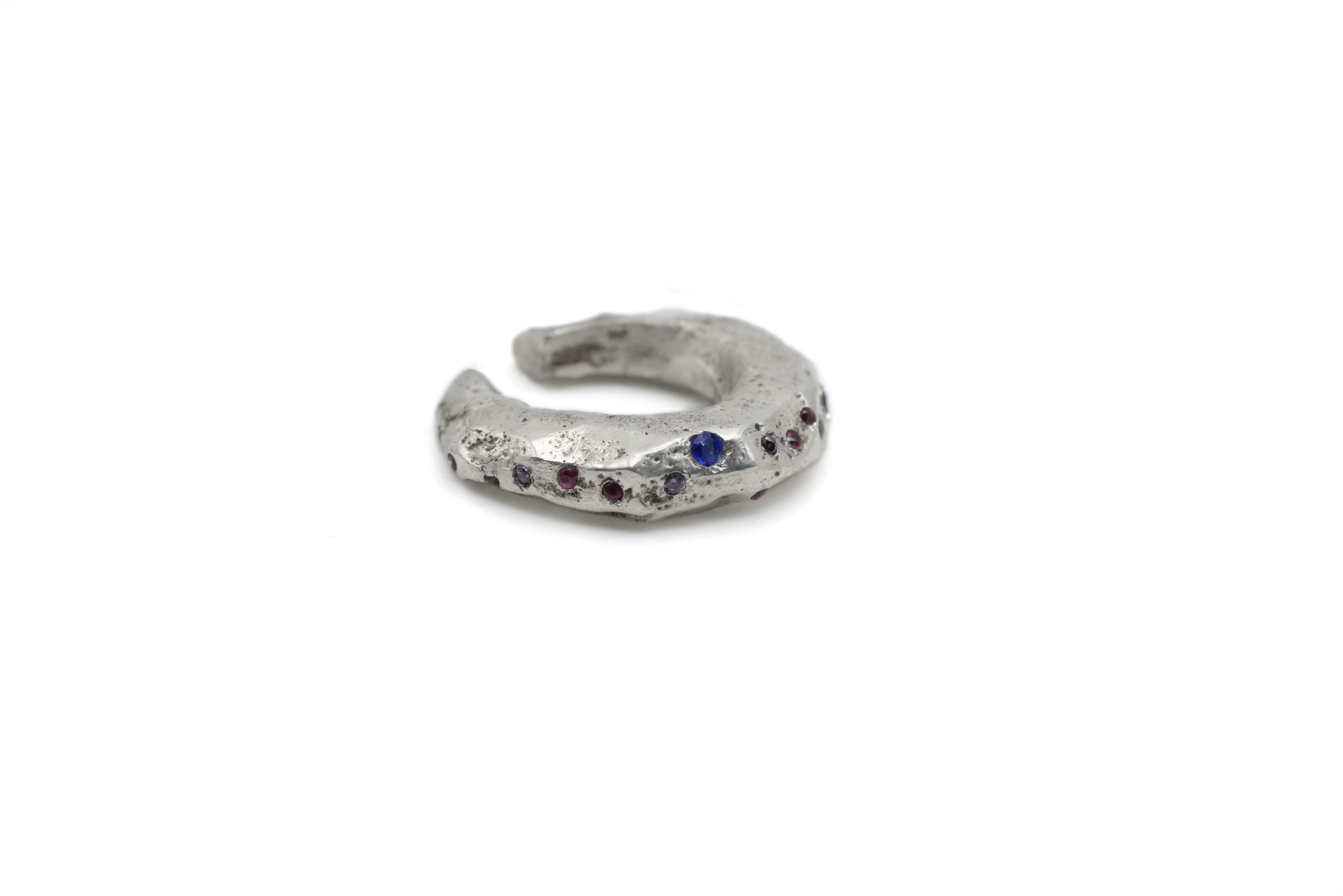 Close-up of VAN GOGH ear cuff showing hand-carved swirling details and hand-set rainbow zircons
